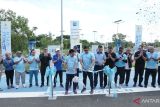 General Manager PT PLN (Persero) Unit Induk Distribusi Kalimantan Selatan dan Kalimantan Tengah Ahmad Syauki dan Airport Technical Division Head Bandara Syamsudin Noor Banjarmasin Budhi Rano Sulistyo melakukan pengguntingan pita pada peresmian fasilitas Stasiun Pengisian Kendaraan Listrik Umum (SPKLU) yang bekerja sama dengan InJourney di Bandara Syamsudin Noor Banjarmasin di Banjarbaru, Jumat (28/2/2025).
