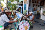 Sejumlah seniman melukis bersama pada acara ngabuburit seniman lukis di Ketapang, Banyuwangi, Jawa Timur, Selasa (4/3/2025). Memanfaatkan waktu menjelang berbuka puasa sejumlah seniman lukis di Banyuwangi mengadakan acara melukis bersama sebagai upaya mengenalkan karyanya kepada masyarakat luas guna membuka peluang ekonomi bagi para seniman. ANTARA Jatim/Budi Candra Setya/mas.