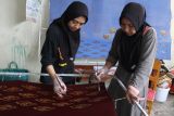 Pekerja mewarnai batik bermotif Garudeya di rumah produksi Batik Mojo, Kepanjen, Malang, Jawa Timur, Rabu (5/3/2025). Pengusaha batik setempat menggunakan motif kuno dari relief candi Kidal yakni buah mojo, medali dan garudeya sebagai ciri khas corak kain batik untuk kemudian dijual ke berbagai daerah melalui media sosial dengan  harga Rp150 ribu hingga Rp900 ribu per lembar dengan rata-rata jumlah produksi per hari sebanyak 20 lembar. Antara Jatim/Ari Bowo Sucipto/um