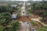 Foto udara warga menyaksikan kondisi jalan lintas Sumatera yang amblas di Desa Sirih Sekapur, Bungo, Jambi, Rabu (5/3/2025). Jalan nasional yang menghubungkan Provinsi Jambi dengan Sumatera Barat yang amblas pada Minggu (2/3) akibat hujan deras itu hingga Rabu (5/3) pagi masih belum bisa dilintasi, sementara Balai Pelaksana Jalan Nasional (BPJN) Jambi masih berupaya membangun jembatan darurat. ANTARA FOTO/Wahdi Septiawan/nym.
