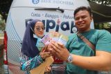 Warga memperlihatkan uang rupiah baru hasil penukaran pada mobil kas keliling Bank Indonesia saat kegiatan bertajuk Semarak Rupiah Ramadhan dan Berkah Idul Fitri (Serambi) 2025 di Kabupaten Kediri, Jawa Timur, Kamis (6/3/2025). Kantor perwakilan Bank Indonesia Kediri bekerjasama dengan perbankan menyediakan layanan penukaran uang rupiah layak edar melalui kegiatan Serambi 2025 di 70 titik yang tersebar di 13 Kabupaten/Kota dengan jumlah Rp4,9 triliun untuk memenuhi kebutuhan masyarakat pada periode Ramadhan dan Idul Fitri. ANTARA Jatim/Prasetia Fauzani/mas.
