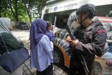 Personil Brimob melakukan penjagaan saat warga menukarkan uang baru di layanan mobil kas keliling Bank Indonesia di Alun Alun Sidoarjo, Jawa Timur, Kamis (6/3/2025). Bank Indonesia bekerja sama dengan perbankan menyediakan layanan penukaran pecahan uang rupiah baru di seluruh Indonesia dengan uang layak edar (ULE) sebesar Rp 180,9 triliun dalam rangka memenuhi kebutuhan masyarakat pada bulan Ramadhan dan Idul Fitri 1446 H. Antara Jatim/Umarul Faruq