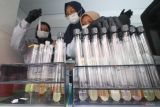 Petugas Badan Pengawasan Obat dan Makanan (BPOM) mengamati tabung reaksi saat uji kelayakan makanan dan minuman pada laboratorium keliling di pasar takjil musiman, Kota Kediri, Jawa Timur, Jumat (7/3/2025). Uji 30 sampel makanan dan minuman tersebut guna mengantisipasi peredaran takjil tidak layak konsumsi seperti mengandung formalin, boraks, pewarna tekstil atau zat berbahaya lainnya. Antara Jatim/Prasetia Fauzani/um