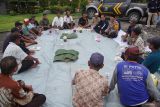 Kapolsek Jombang, AKP Soesilo (tengah) memberikan sosialisasi Kamtimbas kepada tukang becak dan masyarakat umum di sela-sela pembagian sembako dan buka bersama di Alun-alun Kabupaten Jombang, Jawa Timur, Jumat (7/3/2025). Kegiatan buka bersama dan pembagian sembako ini dilakukan Polres Jombang untuk menyerap aspirasi masyarakat, serta mengajak menjaga keamanan dan ketertiban masyarakat (Kamtibmas). Antara Jatim/Syaiful Arif/um