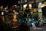 Warga mendorong motornya yang mogok akibat melintasi jalan yang tergenang banjir di Ciwastra, Bandung, Jawa Barat, Jumat (7/3/2025). Sejumlah wilayah di Kota Bandung tergenang banjir setinggi 30 - 50 sentimeter akibat diguyur hujan deras pada Jumat petang hingga malam hari. ANTARA FOTO/Raisan Al Farisi/agr