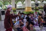 Badut Syariah Yahya Edward melakukan trik sulap saat menyampaikan dongeng pada Gebyar Ramadhan Kariim Al-Ittihad di Masjid Al-Ittihad, Kota Tangerang, Banten, Jumat (7/3/2025). Dongeng yang menceritakan akhlak dan adab terhadap orang tua tersebut dilakukan untuk menghibur anak-anak sambil menunggu waktu untuk berbuka puasa . ANTARA FOTO/Putra M. Akbar/gp