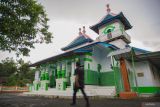 Warga melintas menuju Masjid Baitur Rohman di Desa Tukum, Kecamatan Tekung, Lumajang, Jawa Timur, Sabtu (8/3/2025). Masjid yang memiliki arsitektur atap 9 kubah limas tersebut termasuk salah satu masjid tertua di Lumajang yang dibangun sebelum masa kemerdekaan Indonesia yaitu sekitar tahun 1911. ANTARA Jatim/Irfan Sumanjaya/mas.