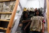 Perajin Siti Mudrikah (kiri) memastikan ketepatan ukuran busana corak daun ecoprint hasil produksinya sebelum dijual di Sanggar Kreasi Mamalya, Malang, Jawa Timur, Sabtu (8/3/2025). Dalam sebulan lebih dari seribu buah produk bercorak daun ecoprint  berbagai jenis antara lain kain, kemeja, sepatu, sofa dan toples kue lebaran mampu terjual ke mancanegara dan berbagai kota di Indonesia melalui media sosial dengan harga Rp15 ribu hingga Rp5 juta menurut jenis produknya. ANTARA Jatim/Ari Bowo Sucipto/mas.