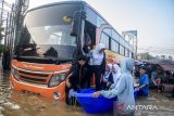 Pekerja menggunakan jasa ojek perahu untuk melintasi banjir di ruas Jalan Raya Dayeuhkolot, Kabupaten Bandung, Jawa Barat, Sabtu (8/3/2025). Sebanyak 60 pekerja pabrik di kawasan tersebut terpaksa menggunakan jasa ojek perahu dengan membayar Rp5.000 hingga Rp10.000 per orang untuk melintas karena terdampak banjir luapan Sungai Citarum yang merendam jalan dan membuat sejumlah kendaraan mogok. ANTARA FOTO/Novrian Arbi/agr
