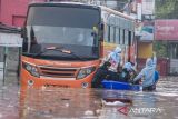 Pekerja menggunakan jasa ojek perahu untuk melintasi banjir di ruas Jalan Raya Dayeuhkolot, Kabupaten Bandung, Jawa Barat, Sabtu (8/3/2025). Sebanyak 60 pekerja pabrik di kawasan tersebut terpaksa menggunakan jasa ojek perahu dengan membayar Rp5.000 hingga Rp10.000 per orang untuk melintas karena terdampak banjir luapan Sungai Citarum yang merendam jalan dan membuat sejumlah kendaraan mogok. ANTARA FOTO/Novrian Arbi/agr

