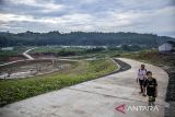 Warga berjalan di dekat proyek zona perluasan atau zona 5 Tempat Pembuangan Akhir (TPA) Sarimukti, Cipatat, Kabupaten Bandung Barat, Jawa Barat, Minggu (9/3/2025). Pembangunan zona perluasan TPA Sarimukti yang mengusung sistem sanitary landfill seluas 6,3 hektare tersebut saat ini dalam tahap pemasangan geomembrane dan ditargetkan rampung serta mulai beroperasi pada Juni 2025. ANTARA FOTO/Abdan Syakura/agr
