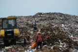 Pelerja mengoperasikan alat berat untuk mendorong sampah ke tengah sementara pemulung asyik mengais barang bekas/rosok di TPA(Tempat Pembuangan Akhir) Segawe, Tulungagung, Jawa Timur, Senin (10/3/2025). Pemkab Tulungagung berencana membangun TPA baru di wilayah selatan karena TPA lama (TPA Segawe) yang dibangun sejak 1990 dengan luas 35 hektare saat ini mendekati penuh dan diperkirakan hanya bisa bertahan dioperasikan hingga 2026. ANTARA Jatim/Destyan Sujarwoko/mas.