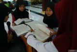 Santriwati membaca alquran bersama di serambi Masjid Kasepuhan Pardikan Majan, Tulungagung, Jawa Timur, Selasa (11/3/2025). Sebanyak 40 santri yang dibagi ke dalam tiga kelompok usia dini dilatih membaca Al Quran masing-masing satu juz per hari hingga para santri fasih dan berhasil khatam di akhir Ramadhan. Antara Jatim/Destyan Sujarwoko/um