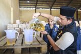 Kasatreskrim Polresta Samarinda AKP Dicky Anggi Pranata (kanan) menuangkan Minyakita kemasan pouch ke dalam gelas ukur saat melakukan sidak terhadap ketersediaan bahan pokok penting (bapokting) di gudang distributor Minyakita di Samarinda, Kalimantan Timur, Selasa (11/3/2025). Sidak yang dilakukan Satgas pangan Polresta Samarinda ke gudang distributor dan pengecer tersebut sebagai tanggapan terhadap keresahan masyarakat terkait dugaan perbedaan isi minyak goreng dengan label yang tertera pada kemasan. Antara Kaltim/M Risyal Hidayat
