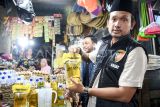 Kasatreskrim Polresta Samarinda AKP Dicky Anggi Pranata (kanan) didampingi satgas pangan menunjukkan Minyakita kemasan pouch saat melakukan sidak terhadap ketersediaan bahan pokok penting (bapokting) di Pasar Segiri, Samarinda, Kalimantan Timur, Selasa (11/3/2025). Sidak yang dilakukan Satgas pangan Polresta Samarinda ke gudang distributor dan pengecer tersebut sebagai tanggapan terhadap keresahan masyarakat terkait dugaan perbedaan isi minyak goreng dengan label yang tertera pada kemasan. Antara Kaltim/M Risyal Hidayat