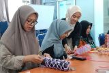 Peserta pelatihan memperlihatkan tali makrame yang digunakan dalam membuat kerajinan tangan di Dinas Perpustakaan dan Kearsipan (Disperpusip) Kota Pontianak, Kalimantan Barat, Jumat (7/3/2025). Pelatihan tersebut diadakan Dinas Perpustakaan dan Kearsipan Kota Pontianak guna memperkenalkan seni kerajinan tangan yang menggunakan teknik simpul sekaligus mengasah kreativitas peserta. ANTARA KALBAR/Taras/Jhw