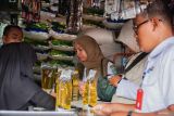 Petugas Dinas Koperasi Usaha Kecil Menengah Perindustrian dan Perdagangan (Diskopindag) Lumajang menakar minyak menggunakan tabung ukur saat sidak di Pasar Baru, Lumajang, Jawa Timur, Rabu (12/3/2025). Kegiatan tersebut dalam rangka mengantisipasi pelanggaran terhadap regulasi harga minyak yang tidak sesuai harga eceran tertinggi (HET) dan memastikan volume sesuai dengan takaran. Antara Jatim/Irfan Sumanjaya/um