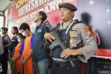Petugas berjaga di samping dua sejoli tersangka perampokan mobil taksi online Toyota Avanza warna hitam dengan Nopol L 1859 BBD di tol Jombang saat rilis ungkap kasus di Polres Jombang, Jawa Timur, Rabu (12/3/2025). Kedua pelaku perampokan mobil taksi online yakni Herlambang Bintara Setiawan (30) dan pasangannya Antika Siti Alpiyah (24) yang kondisinya tengah mengandung berhasil diamankan Polisi di wilayah Blora Jawa Tengah dan diancam hukuman 9 tahun penjara dalam pasal 365 KUHP. Antara Jatim/Syaiful Arif/mas.