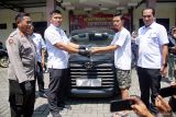 Kasatreskrim Polres Jombang AKP Margono Suhendra (kedua kiri) menyerahkan barang bukti mobil yang dirampok pasangan sejoli di Polres Jombang, Jawa Timur, Rabu (12/3/2025). Kedua pelaku perampokan mobil taksi online yakni Herlambang Bintara Setiawan (30) dan pasangannya Antika Siti Alpiyah (24) yang kondisinya tengah mengandung diamankan Polisi di wilayah Blora Jawa Tengah, mereka diancam hukuman 9 tahun penjara dalam pasal 365 KUHP. Antara Jatim/Syaiful Arif/mas.