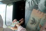 Petugas Bank Indonesia (BI) melayani warga yang melakukan penukaran uang baru di halaman Masjid Agung Kota Blitar, Jawa Timur, Kamis (13/3/2025). Tak hanya warga dari wilayah setempat, sejumlah warga yang berasal dari beberapa kota lain seperti Kediri dan Surabaya juga ikut mengantre untuk mendapatkan pelayanan penukaran pecahan uang baru tersebut dengan alasan keterbatasan kuota. Antara Jatim/Irfan Anshori/um