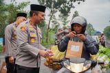 Kapolres Lumajang Alex Sandy Siregar (kiri) membagikan paket takjil kepada pengendara di Randuagung, Lumajang, Jawa Timur, Kamis (13/3/2025). Polres Lumajang membagikan 500 paket takjil gratis kepada pengendara sebagai bentuk kepedulian dan memenuhi kebutuhan berbuka puasa kepada masyarakat pada bulan Ramadhan.  Antara Jatim/Irfan Sumanjaya/um