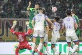 Pesepak bola Persebaya Surabaya Rizky Dwi Pangestu (kedua kiri) berusaha menyundul bola ke arah penjaga gawang PSIS Semarang Syahrul Trisna Fadillah (kiri) pada pertandingan BRI Liga 1 di Stadion Gelora Bung Tomo, Surabaya, Jawa Timur, Rabu (12/3/2025). Pertandingan tersebut berakhir imbang dengan skor 1-1. ANTARA Jatim/Rizal Hanafi/mas.
