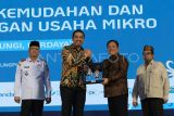  Menteri UMKM Maman Abdurahman (kedua kiri) menerima cinderamata dari Direktur Utama PT Permodalan Nasional Madani (PNM) Arief Mulyadi (kedua kanan) disaksikan Kepala Badan Penyelenggara Jaminan Produk Halal Haikal Hasan (kanan) dan Sekretaris Daerah Provinsi Kalimantan Barat Harisson (kiri) pada Festival Kemudahan dan Pelindungan Usaha Mikro di Pontianak, Kalimantan Barat, Rabu (12/3/2025). Pada acara yang digelar Kementerian UMKM dan PT Permodalan Nasional Madani tersebut dibagikan ribuan sertifikat perizinan kepada para pengusaha UMKM Kalbar antara lain 1.000 Nomor Induk Berusaha dari PT PNM, 7.500 sertifikat halal dari Badan Penyelenggara Jaminan Produk Halal (BPJH) serta 350 Sertifikat Produk Pangan Industri Rumah Tangga dari Dinas Kesehatan Kota Pontianak. ANTARA FOTO/Jessica Wuysang/foc.
