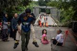 Warga menggendong kerabatnya melewati Jembatan Cicangor yang ambles di Pangkalan, Karawang, Jawa Barat. Jembatan penghubung jalan provinsi yang menjadi akses utama dari Loji menuju Karawang kota atau sebaliknya itu amblas karena terkikis derasnya aliran sungai, akibatnya tidak bisa dilalui kendaraan roda empat maupun roda dua. ANTARA FOTO/Bayu Pratama S/rwa.