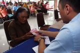 Petugas menyerahkan uang bantuan sosial (bansos) kepada warga lanjut usia (lansia) saat penyerahan bansos Program Keluarga Harapan (PKH) di Kota Madiun, Jawa Timur, Jumat (14/3/2025). Pemkot Madiun menyerahkan bansos PKH dari Pemprov Jawa Timur kepada 258 keluarga penerima manfaat lansia masing-masing sebesar Rp500 ribu guna membantu mencukupi kebutuhan hidup sekaligus sebagai upaya menekan inflasi menjelang lebaran. Antara Jatim/Siswowidodo/um 