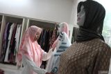 Pekerja menata busana muslim tipe syari yang sedang diminati masyarakat di rumah mode Laila Ghani Malang, Jawa Timur, Jumat (14/3/2025). Menurut pengelola usaha busana muslim setempat tren warna busana muslim menjelang lebaran tahun 2025 adalah warna merah burgundy, hitam serta hijau emerald dengan gaya busana tipe syari dan berbahan kain ceruti premium yang ringan dipadukan motif abstrak sehingga membuat kesan mewah sekaligus elegan. Antara Jatim/Ari Bowo Sucipto/um