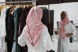 Pekerja menata busana muslim tipe syari yang sedang diminati masyarakat di rumah mode Laila Ghani Malang, Jawa Timur, Jumat (14/3/2025). Menurut pengelola usaha busana muslim setempat tren warna busana muslim menjelang lebaran tahun 2025 adalah warna merah burgundy, hitam serta hijau emerald dengan gaya busana tipe syari dan berbahan kain ceruti premium yang ringan dipadukan motif abstrak sehingga membuat kesan mewah sekaligus elegan. Antara Jatim/Ari Bowo Sucipto/um