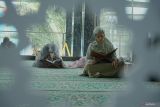 Jamaah putri bertadarus (membaca alquran) sembari menunggu jam berbuka puasa di Masjid modern Al Fattah, Tulungagung, Jawa Timur, Kamis (13/3/2025). Masjid yang terletak di jantung Kota Tulungagung ini memiliki keistimewaan pada desainnya yang dirancang futuristik, hemat energi dan ramah lingkungan melalui pencahayaan alami serta ventilasi udara sehingga mengurangi beban penggunaan listrik untuk lampu maupun pendingin ruangan. ANTARA Jatim/Destyan Sujarwoko/mas.