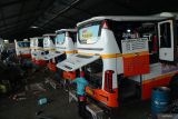 Pekerja melakukan perawatan rutin armada bus di garasi PO Harapan Jaya, Tulungagung, Jawa Timur, Kamis (13/3/2025). Perawatan hingga servis besar dilakukan pelaku usaha jasa angkutan darat itu untuk memastikan seluruh armada bus yang ada siap dikerahkan untuk optimalisasi angkutan mudik/balik Lebaan 2025. ANTARA Jatim/Destyan Sujarwoko/mas.