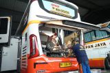 Pekerja melakukan perawatan rutin armada bus di garasi PO Harapan Jaya, Tulungagung, Jawa Timur, Kamis (13/3/2025). Perawatan hingga servis besar dilakukan pelaku usaha jasa angkutan darat itu untuk memastikan seluruh armada bus yang ada siap dikerahkan untuk optimalisasi angkutan mudik/balik Lebaan 2025. ANTARA Jatim/Destyan Sujarwoko/mas.