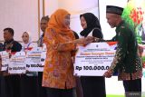 Gubernur Jawa Timur Khofifah Indar Parawansa (kedua kanan) menyerahkan bantuan keuangan khusus untuk program pemberdayaan BUMDes secara simbolis kepada salah satu penerima saat acara kick-off Program dan Pelatihan Mitra Klinik BUMDesa Jatim 2025 di Surabaya Suites Hotel, Kamis (13/3/2025). Kegiatan yang dinisiasi oleh KIP Foundation tersebut bertema “Penguatan Desa Produktif Berbasis BUMDesa sebagai Pilar Ketahanan Pangan untuk Mendukung Program Makan Bergizi Gratis (MBG). ANTARA Jatim/Moch Asim.