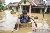 Anak-anak bermain di lokasi banjir Dayeuhkolot, Kabupaten Bandung, Jawa Barat, Minggu (16/3/2025). Banjir setinggi 30 sentimeter hingga 2 meter akibat luapan air Sungai Citarum saat intensitas curah hujan tinggi kembali merendam tiga kecamatan yakni Bojongsoang, Baleendah, dan Dayeuhkolot di Bandung Selatan. ANTARA FOTO/Novrian Arbi/agr