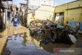 Warga berjalan melintasi banjir di Dayeuhkolot, Kabupaten Bandung, Jawa Barat, Minggu (16/3/2025). Banjir setinggi 30 sentimeter hingga 2 meter akibat luapan air Sungai Citarum saat intensitas curah hujan tinggi kembali merendam tiga kecamatan yakni Bojongsoang, Baleendah, dan Dayeuhkolot di Bandung Selatan. ANTARA FOTO/Novrian Arbi/agr
