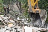 Warga mencari besi dan puing-puing bangunan di samping ekskavator yang membongkar rumah di bantaran Kali Sepak, Gabus, Tambun Utara, Kabupaten Bekasi, Jawa Barat, Senin (7/3/2025). Pemerintah Provinsi Jawa Barat berupaya menormalisasi kali dengan membongkar bangunan liar sepanjang 5 km di bantaran Kali Sepak yang alirannya menuju Kali CBL (Cikarang Bekasi Laut) untuk mencegah banjir yang kerap terjadi di daerah tersebut. ANTARA FOTO/ Fakhri Hermansyah/rwa.