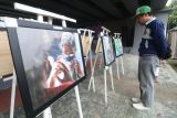 Pengunjung mengamati karya foto saat pameran foto 5 tahun Covid-19 di Kota Kediri, Jawa Timur, Selasa (18/3/2025). Pameran foto yang menampilkan 15 karya dari empat fotografer lokal Kediri tersebut guna mengenang Covid-19 sebagai upaya mengingatkan kembali masyarakat untuk menerapkan gaya hidup bersih dan sehat agar pandemi tidak terulang kembali. Antara Jatim/Prasetia Fauzani/um