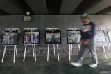 Pengunjung berjalan di depan karya foto saat pameran foto 5 tahun Covid-19 di Kota Kediri, Jawa Timur, Selasa (18/3/2025). Pameran foto yang menampilkan 15 karya dari empat fotografer lokal Kediri tersebut guna mengenang Covid-19 sebagai upaya mengingatkan kembali masyarakat untuk menerapkan gaya hidup bersih dan sehat agar pandemi tidak terulang kembali. Antara Jatim/Prasetia Fauzani/um