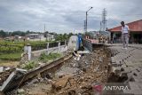 Pengurus pasar melihat bangunan dan lahan parkir yang amblas di Pasar Curug Agung Baru Gedong Lima, Padalarang, Kabupaten Bandung Barat, Jawa Barat, Rabu (19/3/2025). Tingginya intensitas hujan serta labilnya tanah di kawasan tersebut menyebabkan sejumlah fasilitas seperti lahan parkir, toilet umum, pos satpam, dan tempat penampungan sampah sementara di pasar itu amblas sekitar 1 meter dengan panjang 15 meter. ANTARA FOTO/Abdan Syakura/agr
