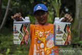 Petani menunjukkan pupuk organik cair dalam kemasan jeriken di Desa Mekar Baru, Petir, Kabupaten Serang, Banten, Rabu (19/3/2025). Pupuk organik dari urin kelinci tersebut diolah dengan cara difermentasi menggunakan campuran effective microorganism 4 (EM4) dan molase atau tetes tebu sehingga menghasilkan cairan yang dapat digunakan sebagai pupuk tanaman yang dijual dengan harga Rp50 ribu per dua liter. ANTARA FOTO/Angga Budhiyanto/gp