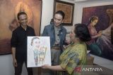 Menteri Pariwisata Widiyanti Putri Wardhana (tengah) menerima lukisan diri dari seniman Rumah Seni Ropih saat melakukan kunjungan kerja di kawasan Braga, Bandung, Jawa Barat, Rabu (19/3/2025). Kunjungan Menteri Pariwisata tersebut untuk meninjau suasana dan kenyamanan sejumlah titik wisata Kota Bandung yang menjadi salah satu tujuan wisata saat libur Lebaran. ANTARA FOTO/Novrian Arbi/agr
