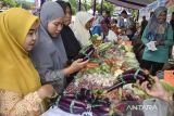 Warga membeli sayuran saat Gerakan Pangan Murah (GPM) di Kecamatan Cijengjing, Kabupaten Ciamis, Jawa Barat, Rabu (19/3/2025). Badan Pangan Nasional (Bapanas) mencatat perkembangan program Operasi Pasar Pangan Murah telah semakin meluas dan per 10 Maret 2025 total sebaran lokasi ada di 1.534 titik di 34 provinsi dan 394 kabupaten/kota, sementara target persebaran yang telah ditetapkan sebanyak 6.845 lokasi se-Indonesia. ANTARA FOTO/Adeng Bustomi/agr