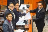 Menteri Hukum Supratman Andi Agtas (kanan) berjabat tangan dengan Ketua Komisi I DPR RI Utut Adianto (kedua kanan) disaksikan oleh Wakil Ketua Komisi I DPR RI Dave Laksono (kedua kiri) dan Ahmad Heryawan (kiri) saat rapat persetujuan tingkat I RUU TNI di Kompleks Parlemen, Senayan, Jakarta, Selasa (18/3/2025). Komisi I DPR menyetujui pembahasan Rancangan Undang-Undang (RUU) tentang Perubahan atas Undang-Undang Nomor 34 Tahun 2004 tentang Tentara Nasional Indonesia (TNI) pada tingkat I, untuk dibawa ke tingkat selanjutnya di Rapat Paripurna DPR. ANTARA FOTO/Rivan Awal Lingga/nz