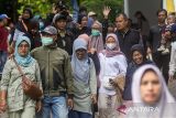 Pemudik berjalan menuju bus saat pelepasan program mudik gratis di lapangan Pemkot Cimahi, Kota Cimahi, Jawa Barat, Sabtu (29/3/2025). Pemerintah Kota Cimahi memberangkatkan sebanyak 585 pemudik dengan menggunakan 15 bus ke berbagai daerah tujuan seperti Cirebon, Semarang, Yogyakarta dan Solo secara gratis sebagai program bantuan sekaligus upaya mengurangi penggunaan kendaraan pribadi saat mudik. ANTARA FOTO/Abdan Syakura/agr