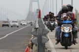 Sejumlah pengendara motor melintas di Jembatan Suramadu, Jawa Timur, Minggu (30/3/2025). Sehari menjelang Hari Raya Idul Fitri 1446 H jembatan tersebut dipadati kendaraan terutama kendaraan roda dua yang menuju ke Pulau Madura. ANTARA Jatim/Didik Suhartono/mas.