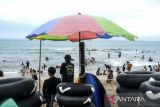 Sejumlah wisatawan bermain air di Pantai Anyer, Kabupaten Serang, Banten, Selasa (1/4/2025). Pemerintah Provinsi Banten memprediksi selama libur Lebaran 2025 sebanyak 840.000 wisatawan akan berkunjung ke sejumlah wisata di Banten seperti wisata Pantai Anyer yang menjadi wisata favorit masyarakat. ANTARA FOTO/Muhammad Bagus Khoirunas/gp