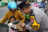 Polisi membagikan makanan ringan ke pemudik yang melintas Jalan Raya Bandar Kedungmulyo, Kabupaten Jombang, Jawa Timur, Kamis (3/4/2025). Pembagian makanan ringan ini sebagai bentuk perhatian petugas serta memberi imbauan agar tetap menjaga keselamatan dalam berkendara saat mudik maupun balik Lebaran. ANTARA Jatim/Syaiful Arif/mas.
