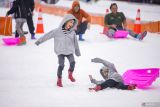 Dua orang anak bermain wahana papan seluncur di Trans Snow World Surabaya, Jawa Timur, Sabtu (5/4/2025). Wisata musim salju buatan tersebut menjadi pilihan alternatif bagi warga Surabaya dan sekitarnya untuk mengisi libur Lebaran 2025. Antara Jatim/Rizal Hanafi/um